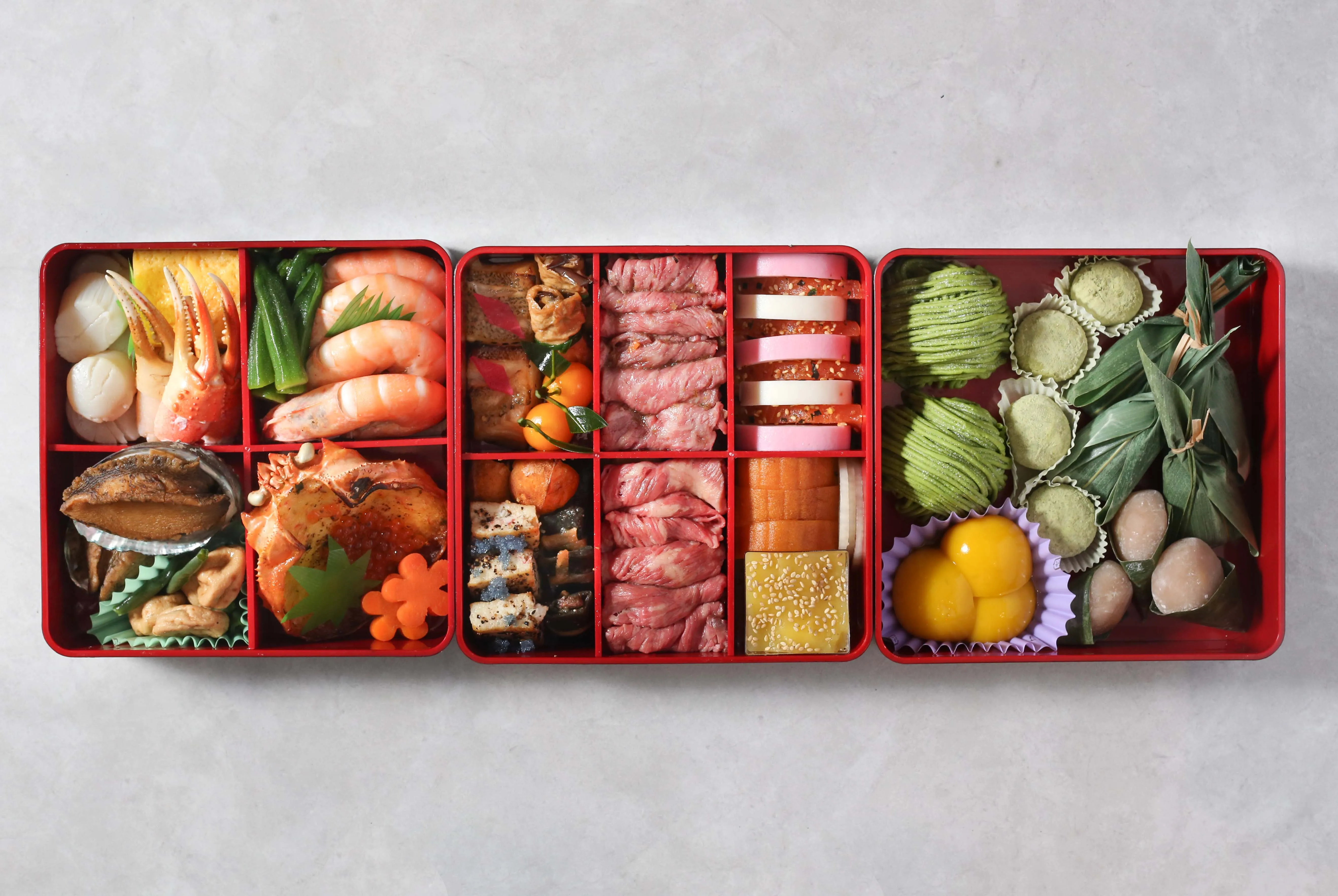 Overhead view of a vibrant osechi box with various Japanese delicacies.