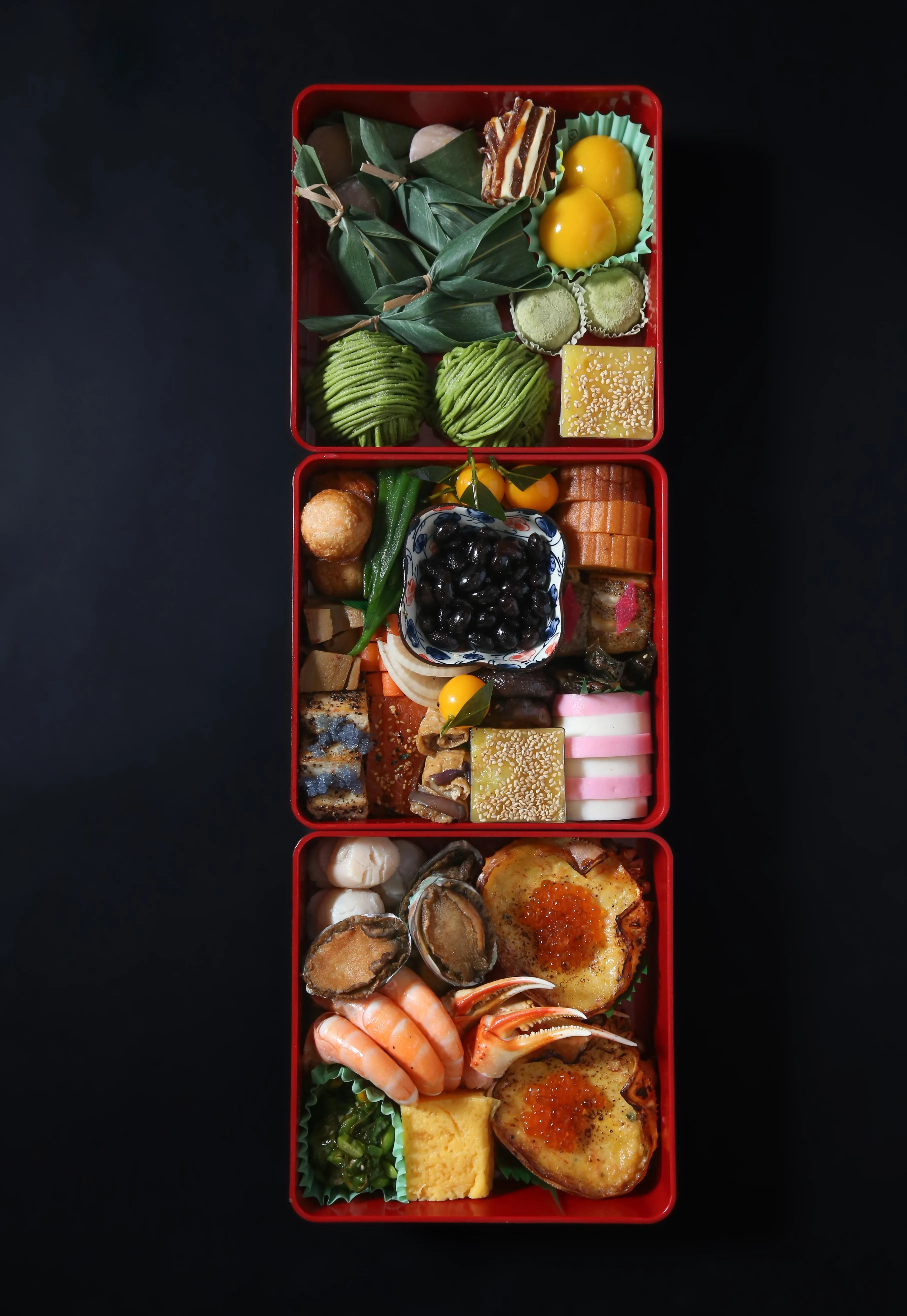 A tiered red lacquer box filled with traditional Japanese Osechi Ryori.