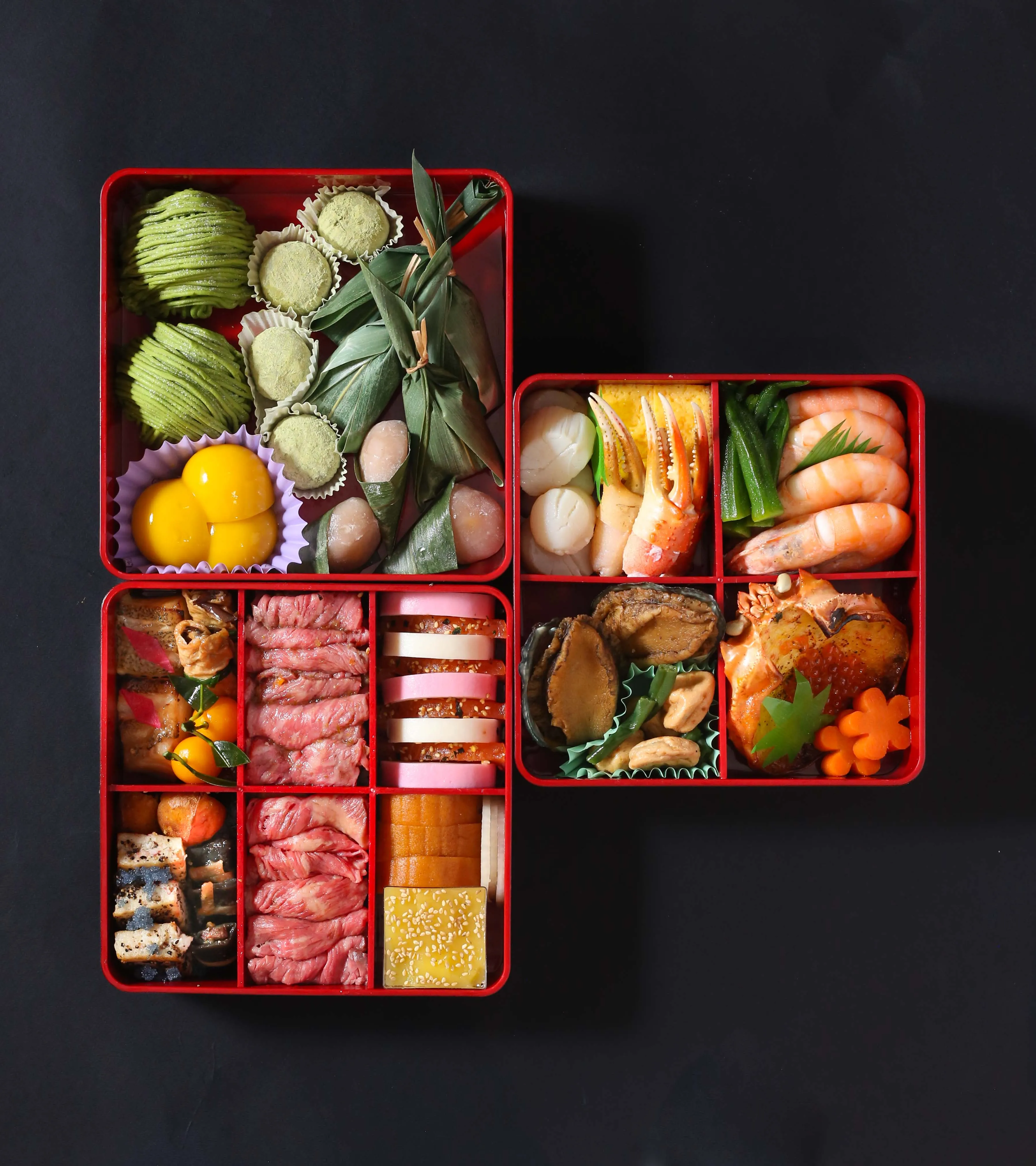 Japanese osechi boxes with various traditional dishes.