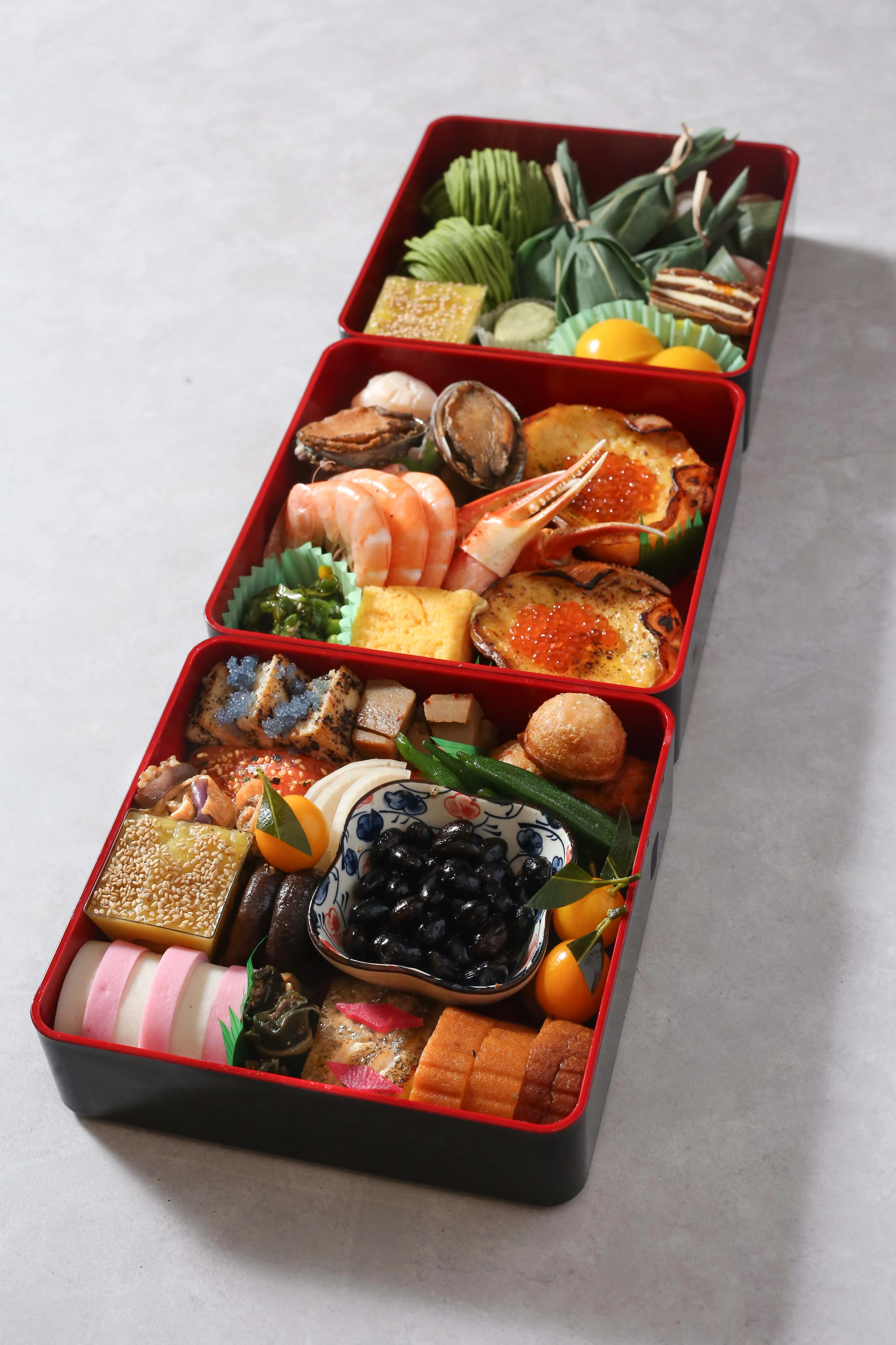 Three-tiered osechi box filled with traditional Japanese New Year foods.